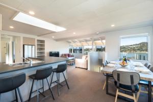 a kitchen and dining room with a table and chairs at The Tide Watcher - Okiato Holiday Home in Opua