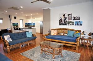 a living room with two couches and a table at 64 Madaffari Drive in Exmouth