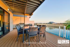 a wooden deck with a table and chairs on a balcony at 33 Inggarda Lane in Exmouth