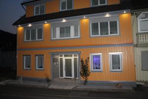 a large orange house with a front door at night at Haus Veni in Bad Grund