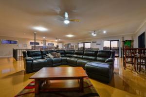 a living room with a leather couch and a coffee table at 16 Crevalle Way in Exmouth