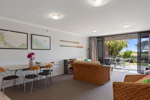 a living room with a table and chairs at The Sandcastle - Papamoa Holiday Apartment in Papamoa