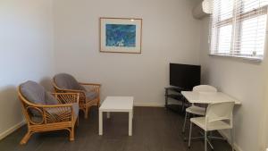a room with chairs and a table and a tv at Getaway Villas Unit 3811 in Exmouth