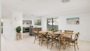 ネルソン・ベイにあるThe Fijian, 52 Lagoons Circuit - Duplex with air con, wi-fi, linen supplied andclose to townのテーブルと椅子のあるキッチンとダイニングルーム