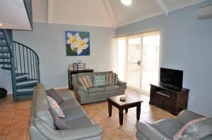 a living room with a couch and a tv at Osprey Holiday Village Unit 115 in Exmouth