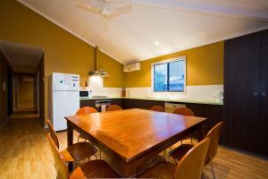 a kitchen with a wooden table and a refrigerator at 9 Skipjack Circle in Exmouth