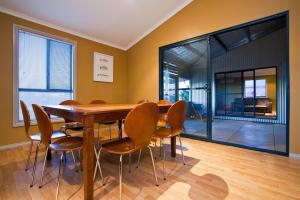 a dining room with a wooden table and chairs at 9 Skipjack Circle in Exmouth