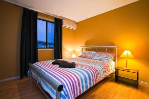 Un dormitorio con una cama grande y una ventana en 9 Skipjack Circle en Exmouth