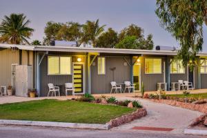 a house with yellow doors and chairs on a street at Getaway Villas Unit 384 in Exmouth