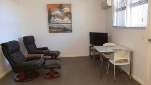 a waiting room with chairs and a table and a television at Getaway Villas Unit 384 in Exmouth