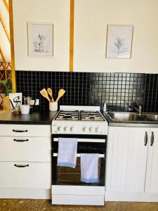 a kitchen with a stove and a sink at Byron Bay Hinterland Eco-Retreat Ivory Yurt in Eureka