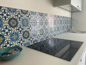 a kitchen with blue and white tiles on the wall at Address Home I Colori Del Mare in Ospedaletti