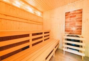 a wooden sauna with a bench in a room at Nadmorska Przystan Apartamenty - Basen, sala zabaw, rowery, animacje in Ustka