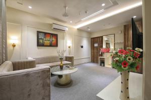 Hotel Royal 9 في ميروت: غرفة معيشة مع أريكة و إناء من الزهور