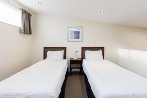 Rúm í herbergi á Fitzherbert Regency Motor Lodge