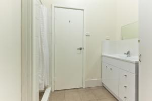 a white bathroom with a sink and a mirror at Exmouth Villas Unit 33 in Exmouth