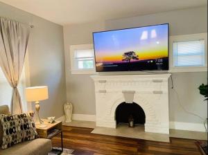 a living room with a tv on top of a fireplace at CHERRY STREET LUXURY- SHOPPING-DINING-BY DOWNTOWN AND HOSPITALs in Tulsa