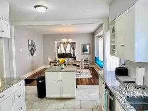 a kitchen with white cabinets and a living room at CHERRY STREET LUXURY- SHOPPING-DINING-BY DOWNTOWN AND HOSPITALs in Tulsa