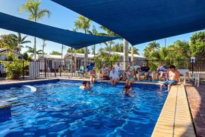 a group of people sitting in a swimming pool at Discovery Parks - Fraser Street, Hervey Bay in Hervey Bay