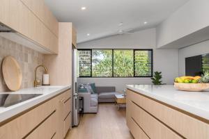 a kitchen with a counter and a living room at The Outlook in Lennox Head +8 photos