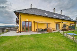 a yellow house with a lawn in front of it at Rezidence Podkova in Frymburk