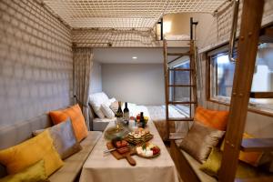 a table in a room with a bunk bed at Fuji Fumoto Forest Hotspring ふもとの森温泉 in Fujikawaguchiko