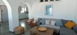 a living room with a blue couch and a table at Teresa's Sunrise in Panormos