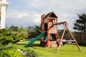 une aire de jeux avec une cabane dans les arbres et un toboggan dans l'établissement Moritz Homestay, à Hualien