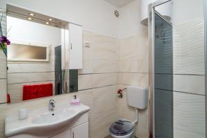 uma casa de banho com um lavatório e um chuveiro em Apartments & Rooms Mara & Petrunjela em Cavtat