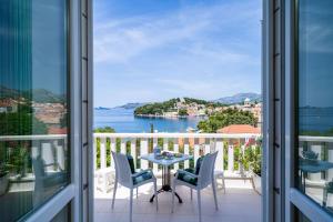 a balcony with a table and chairs and a view of the water at Apartments Mara & Petrunjela in Cavtat