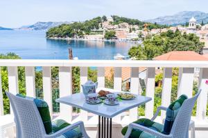 d'une table et de chaises sur un balcon avec vue sur l'eau. dans l'établissement Apartments Mara & Petrunjela, à Cavtat