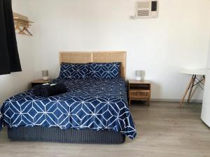 a bedroom with a bed with a blue and white comforter at Shark Bay Cottages in Denham