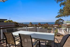 a white table and chairs on a balcony with the ocean at Osullivan - BYO Linen in Lorne