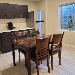 a kitchen with a wooden table with chairs and a refrigerator at Entire Cozy Basement! Private Entrance! - Fast Wifi! in Salt Lake City
