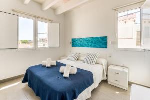 two beds in a bedroom with two windows at Apartamento en Es Grau con vistas in Mahón