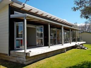 a screened in porch of a house with a roof at Great Escape - Whangamata Holiday Home in Whangamata