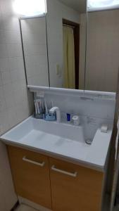 eine Badezimmertheke mit einem Waschbecken und einem Spiegel in der Unterkunft 古民家リゾートハウス　ひみつきち in Kakegawa
