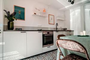a kitchen with white cabinets and a table with a green table cloth at Zagroda “ Leśny Sad” in Bronikowo