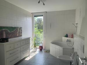 un bagno bianco con vasca e lavandino di House Susanne a Colonia