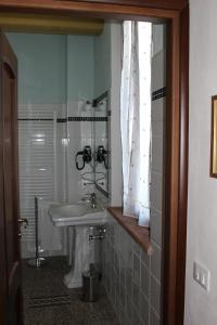 a small bathroom with a sink and a window at Locanda Donna Laura in Imola