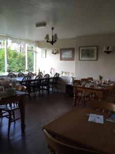 un comedor con mesas, sillas y ventanas en The Crown Hotel, en Horton in Ribblesdale