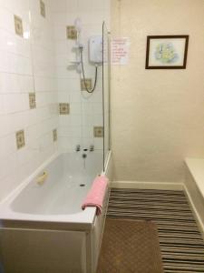 a bathroom with a tub with a pink towel on it at The Crown Hotel in Horton in Ribblesdale