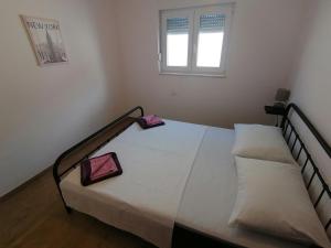 um quarto com uma cama com duas almofadas em Villa Marta 3 bedrooms, 2 baths and pool em Kaštel Štafilić