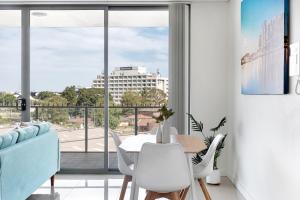 シドニーにあるKOZYGURU Parramatta Lovely 2 BED APT Free Parking NPA006のダイニングルーム(テーブル、椅子付)、大きな窓が備わります。