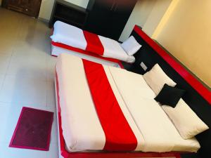 a red and white bed in a room at STAYMAKER Prakash International in Gonikoppal