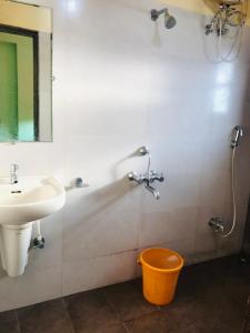 a bathroom with a sink and a toilet and a mirror at STAYMAKER Prakash International in Gonikoppal
