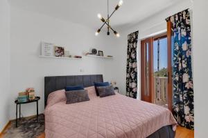 ein Schlafzimmer mit einem Bett mit einer rosa Decke in der Unterkunft Apartman MaRiTo in Selca