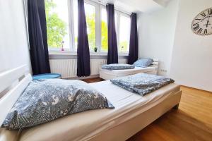 1 dormitorio con 2 camas y reloj en la pared en Langenfeld Apartment en Langenfeld