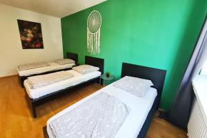 Habitación con 2 camas y pared verde. en Langenfeld Apartment en Langenfeld