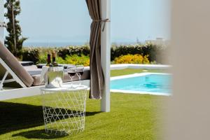 a table with two glasses of wine and a pool at Pyrgaki Beach Villa in Aliko Beach